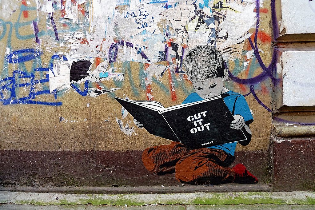 Boy reading a book - street art in Hamburg